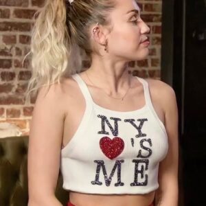 Miley Cyrus radiates effortless charm in a serene halter top and ponytail. Her timeless style is the epitome of grace and beauty.